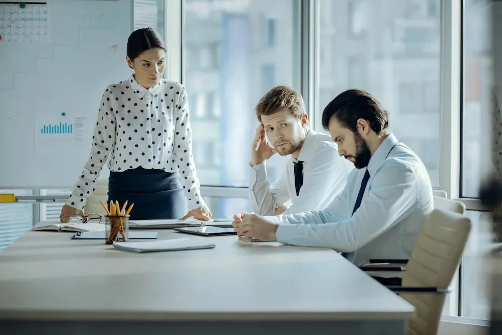 A professional staying calm and composed at their desk while a difficult colleague creates friction nearby, illustrating how to deal with a toxic coworker without losing your cool